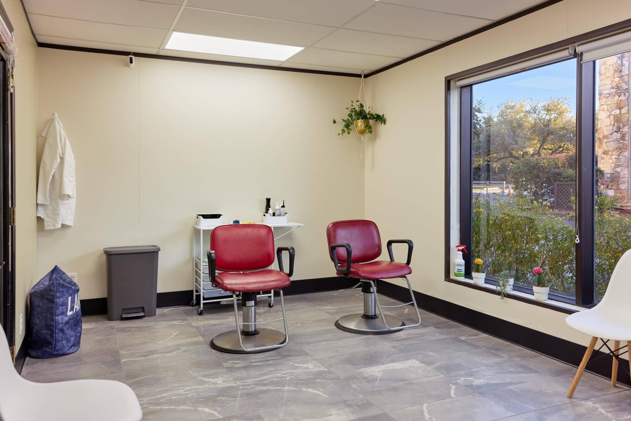 Two burgundy chairs beside a large window