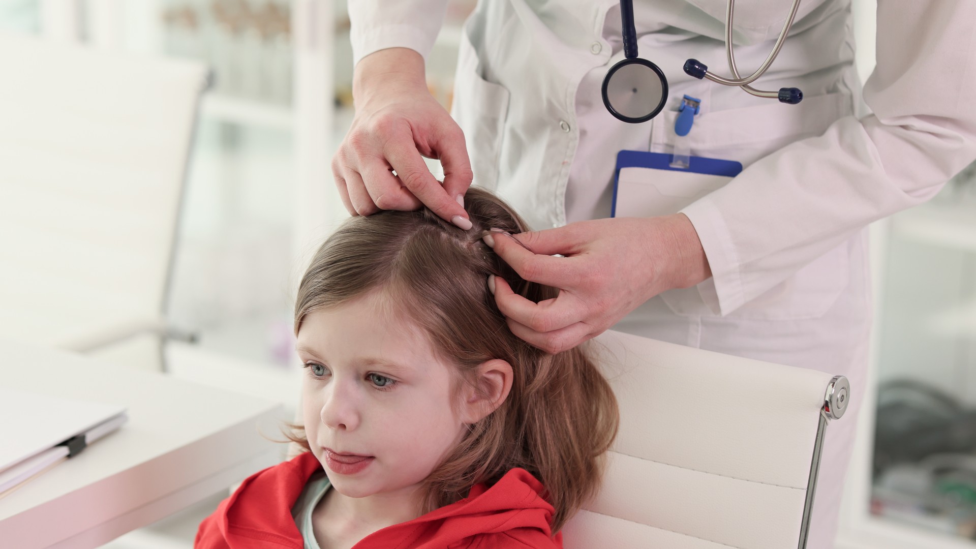 A trained lice technician carefully parts and examines a child's hair section by section to check for live lice and eggs.