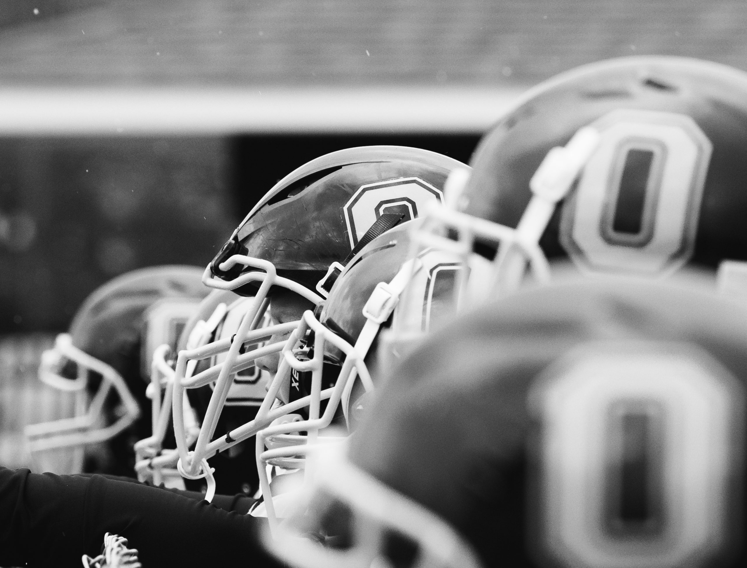 Youth football helmets lined up for a discussion of head lice transmission during sports