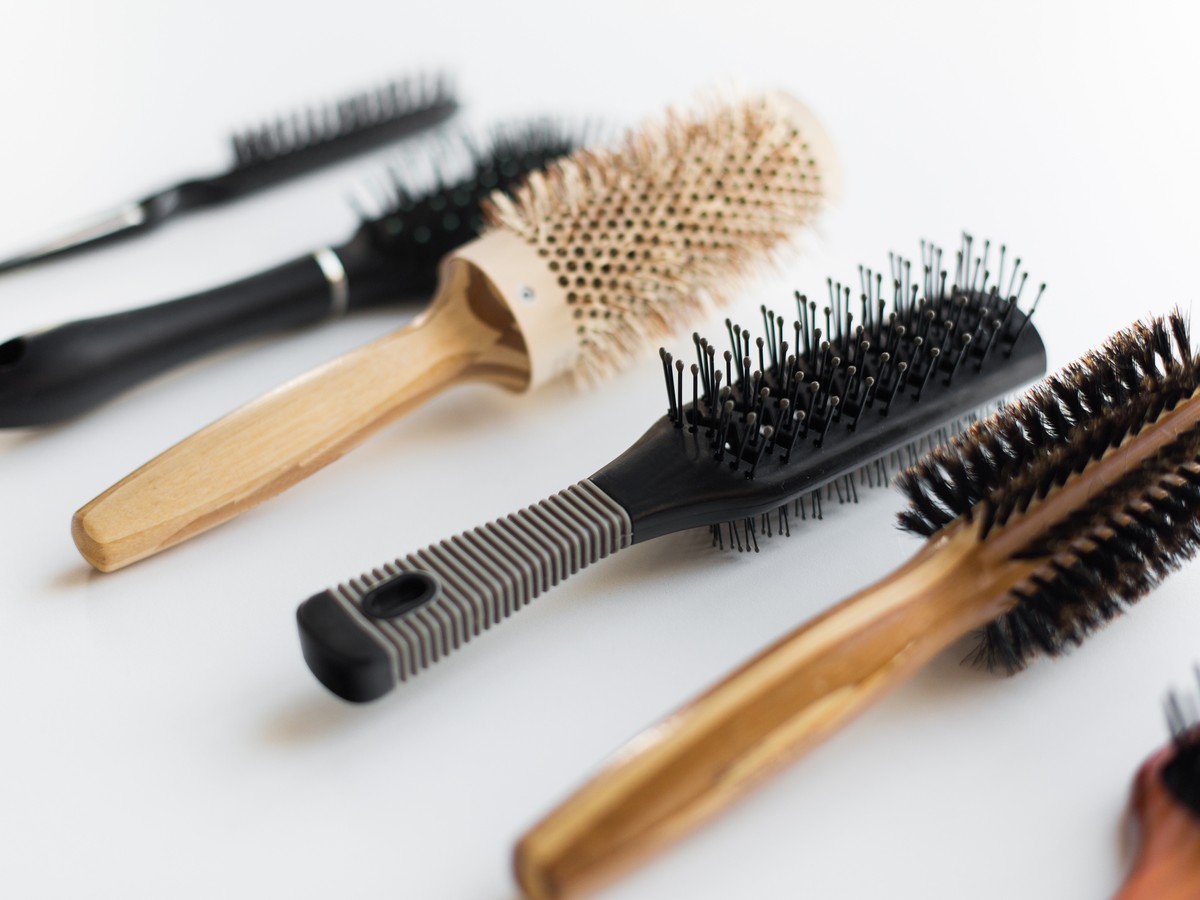 Assorted hair brushes and combs on a white surface