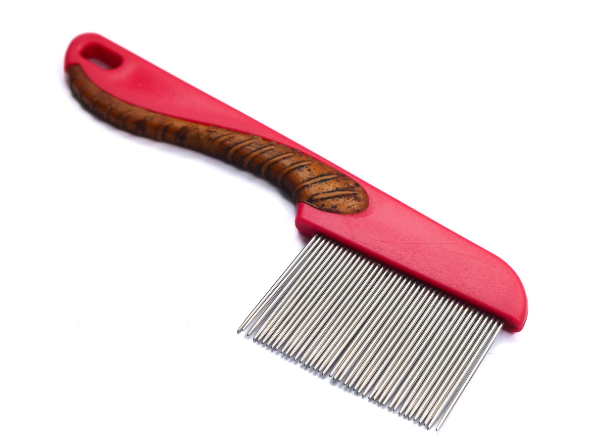 Fine-tooth metal comb with a red handle on a white background