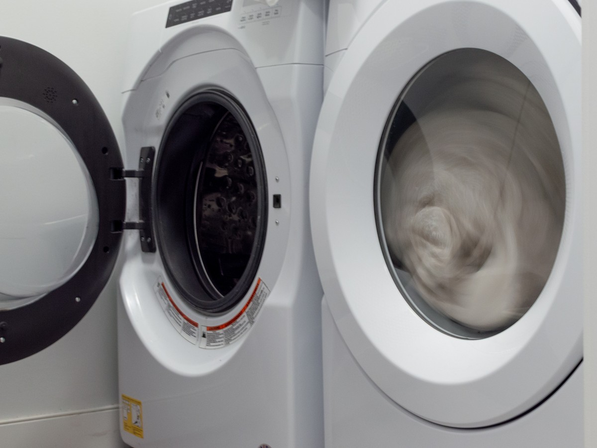 Front-load dryer tumbling laundry in a home laundry room